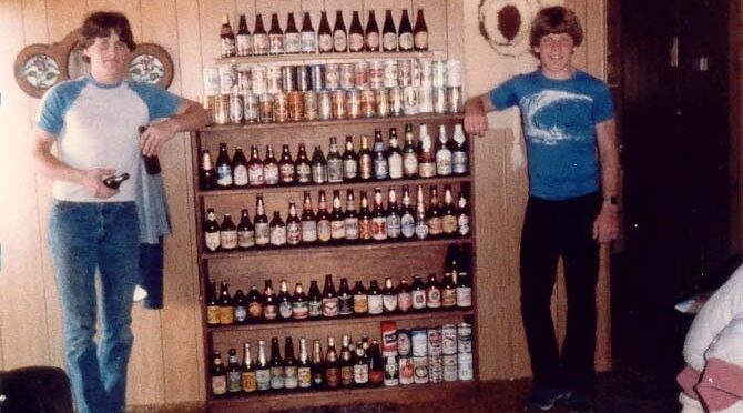 two guys next to shelves with beer bottle collection